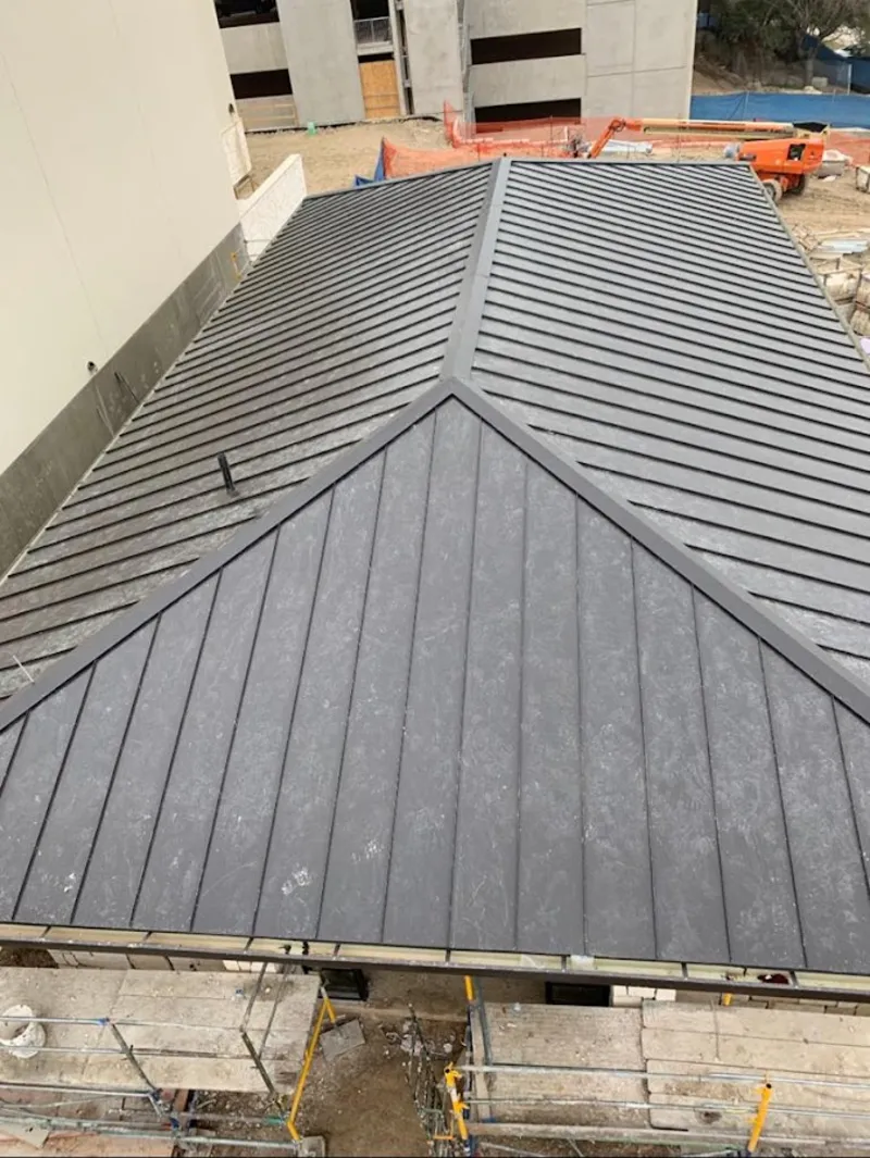 Commercial metal roof construction with crane equipment in Rosedale